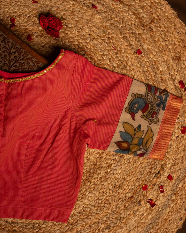 Shoulder side peach blouse best suitable for silk saree kept on the jute round mat.