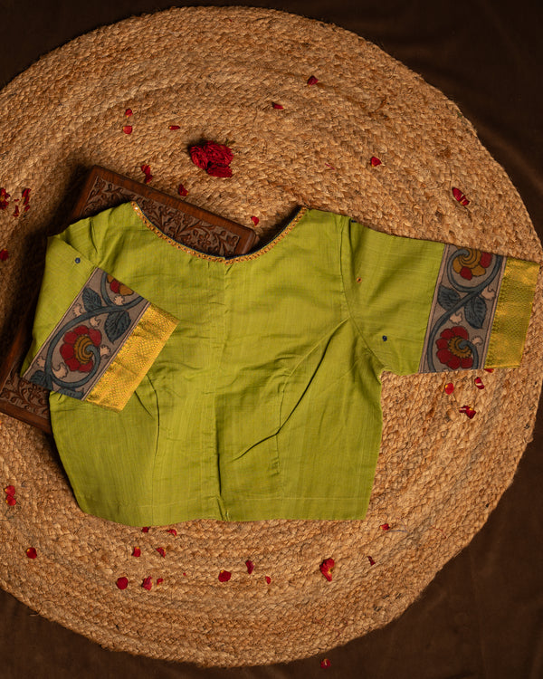 Front side green blouse best suitable for silk saree kept on the jute round mat.