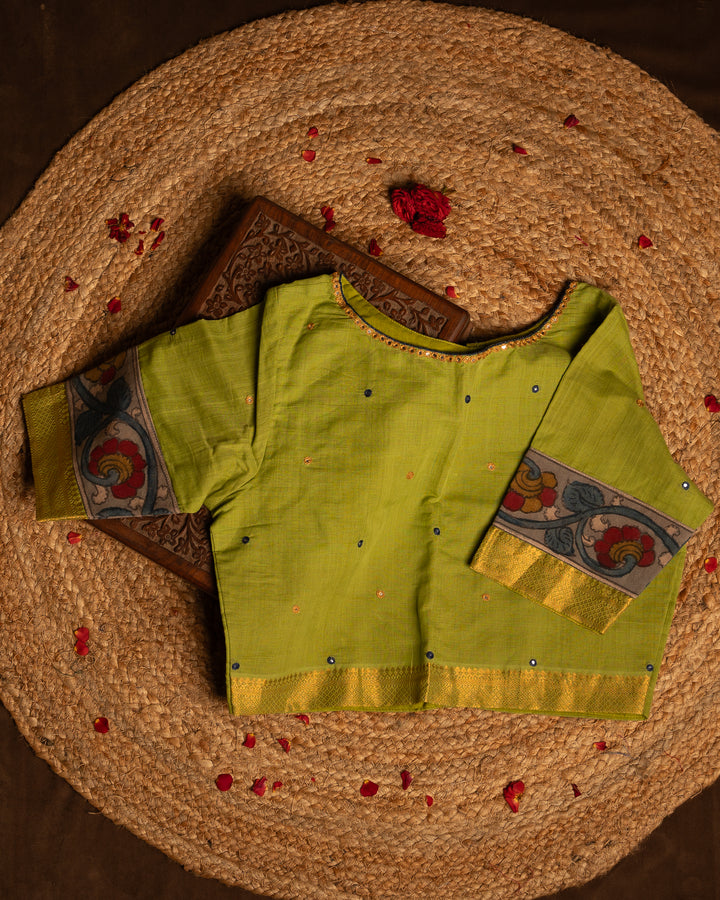 Front side green blouse best suitable for silk saree kept on the jute round mat.