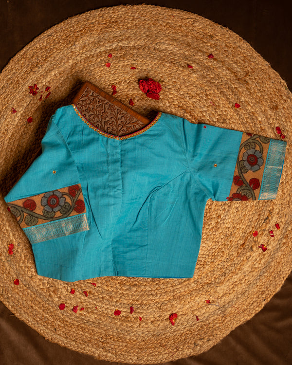 Back side blue blouse best suitable for silk saree kept on the jute round mat.