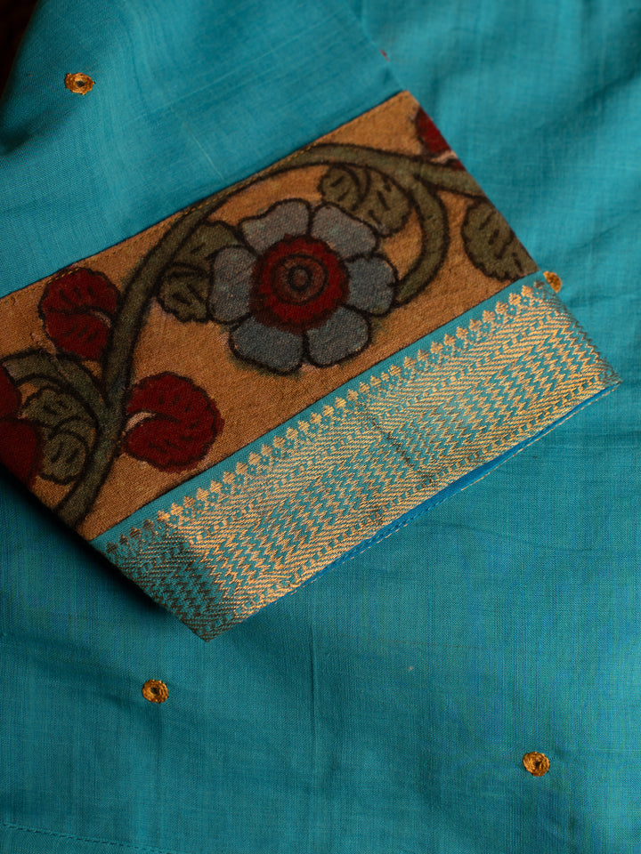 Shoulder side blue blouse best suitable for silk saree kept on the jute round mat.