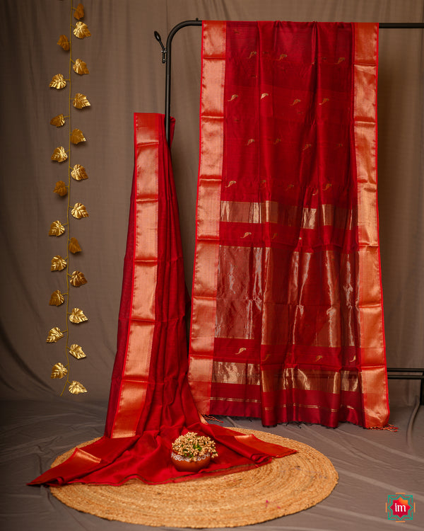 Elegant red handloom cotton saree is pleated and displayed on a stand.