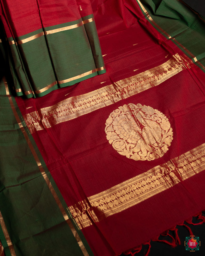 Beautiful red handloom saree is pleated and displayed on the floor.
