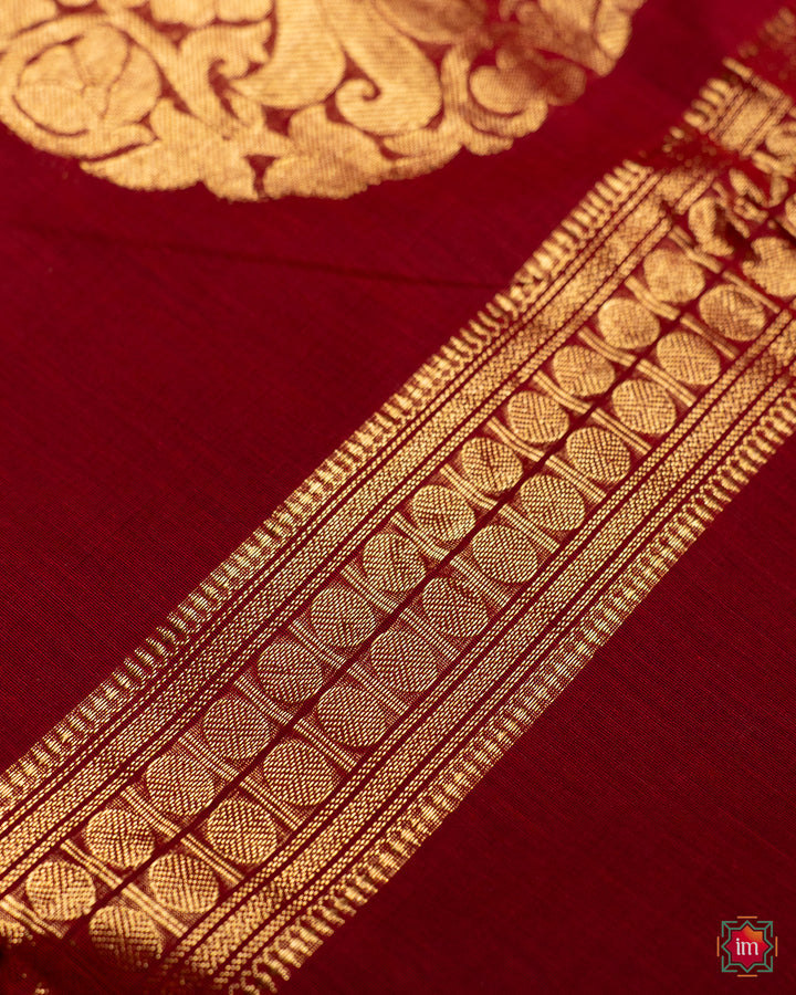 Beautiful red handloom saree, where in the detailed saree print is displayed.