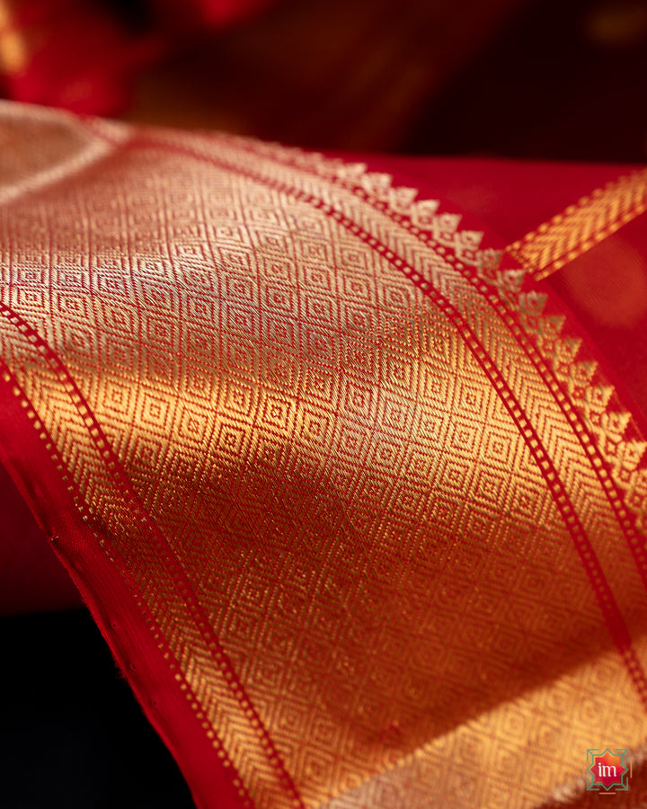 Beautiful red silk saree, where in the detailed saree print is displayed.