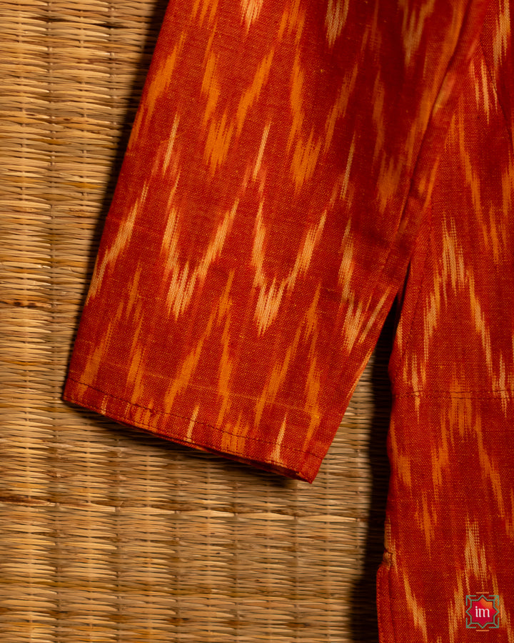 Unisex orange kids kurta, where in the detailed shoulder side print is displayed.