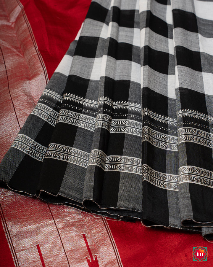 Beautiful white black handloom cotton saree is pleated and displayed on the floor.