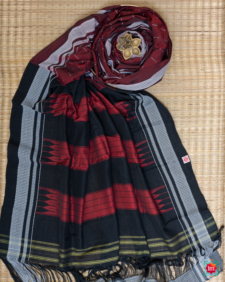 Elegant honey red handloom cotton saree kept on a plate with ganapati statue upon the saree which are kept upon the mat.