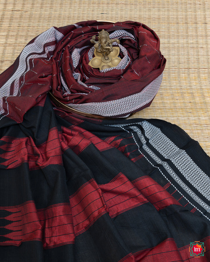 Elegant honey red handloom cotton saree kept on a plate with ganapati statue upon the saree which are kept upon the mat.