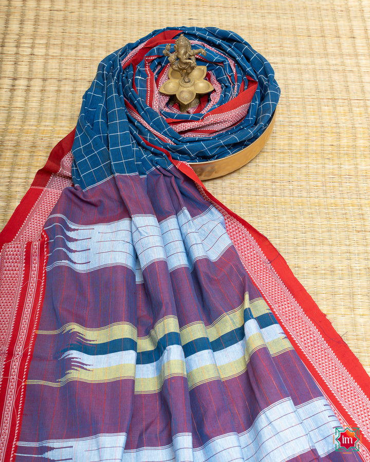 Elegant lake blue handloom cotton saree kept on a plate with ganapati statue upon the saree which are kept upon the mat.
