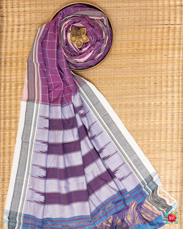 Beautiful orchid purple handloom cotton saree kept on a plate with ganapati statue upon the saree which are kept upon the mat.