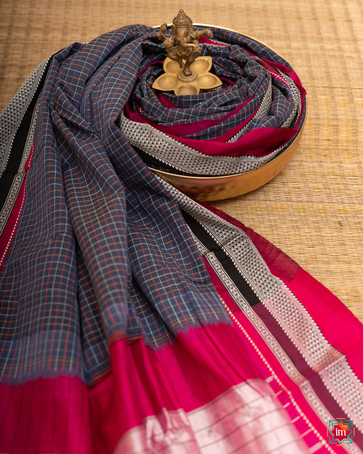 Beautiful blue handloom cotton saree kept on a plate with ganapati statue upon the saree which are kept upon the mat.
