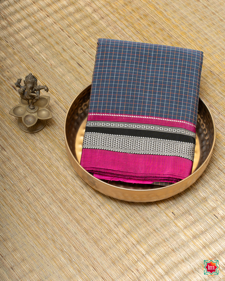 Beautiful blue handloom cotton saree kept on a plate with ganapati statue beside which are kept upon the mat.