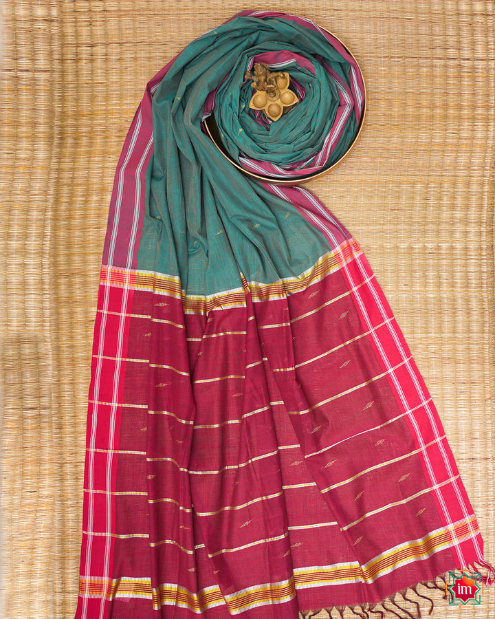 Beautiful udupi handloom cotton saree kept on a plate with ganapati statue upon the saree which are kept upon the mat.