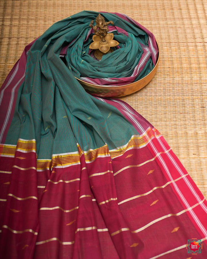 Beautiful udupi handloom cotton saree kept on a plate with ganapati statue upon the saree which are kept upon the mat.