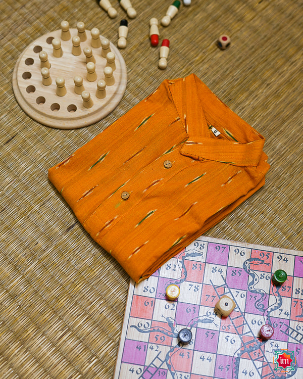 Beautiful yellow girl kurta which is kept on a mat background with some children indoor games which are kept beside.