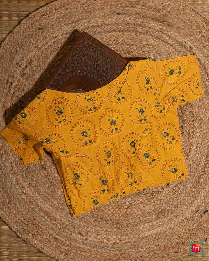 Elegant blouse which would suit any silk saree is kept upon a mat and a wooden designer box.