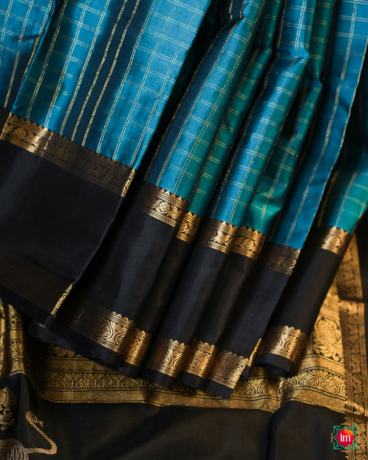 Elegant pacific blue kanjivaram silk saree is pleated and displayed on the floor.
