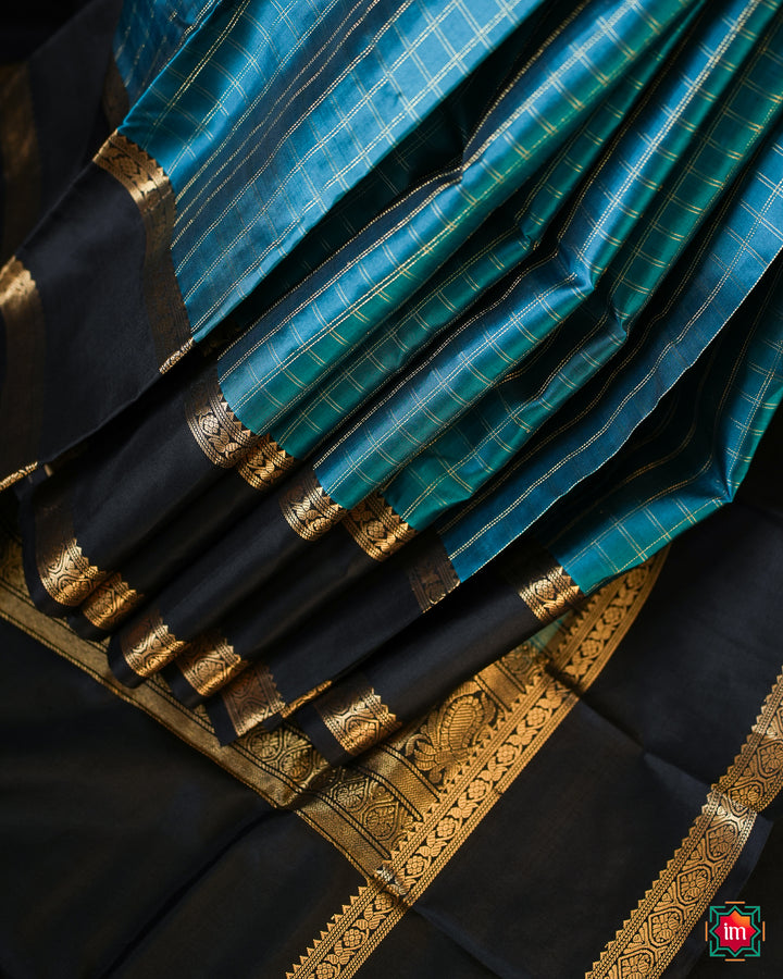 Elegant pacific blue kanjivaram silk saree is pleated and displayed on the floor.
