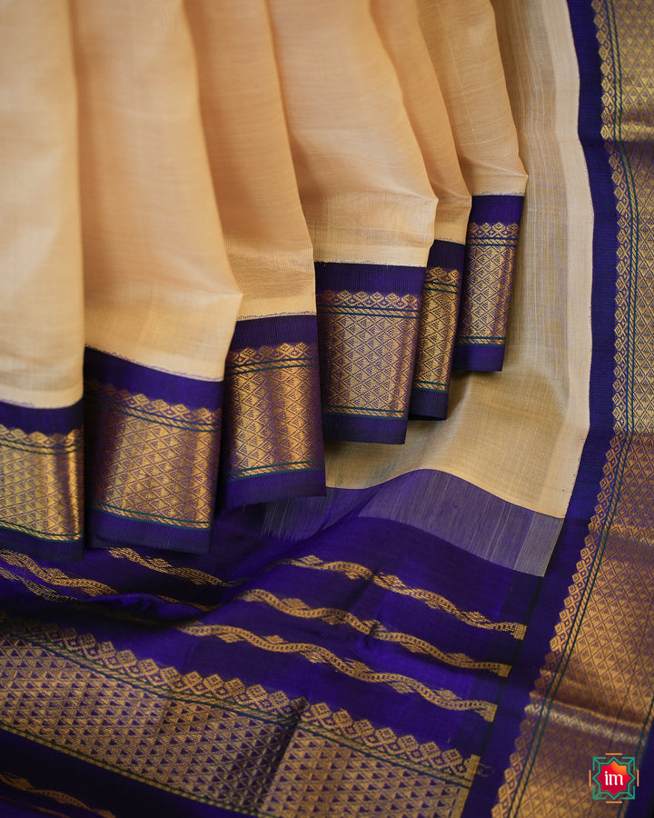 Beautiful Cream Kanchi Silk Cotton Saree best handloom cotton sarees for women is pleated and displayed on the floor.