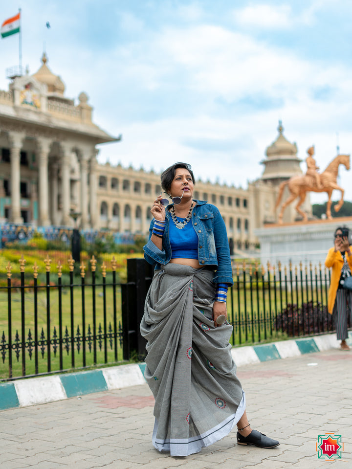 A women posing near Vidhan Soudah by wearing a beautiful grey handloom cotton saree.