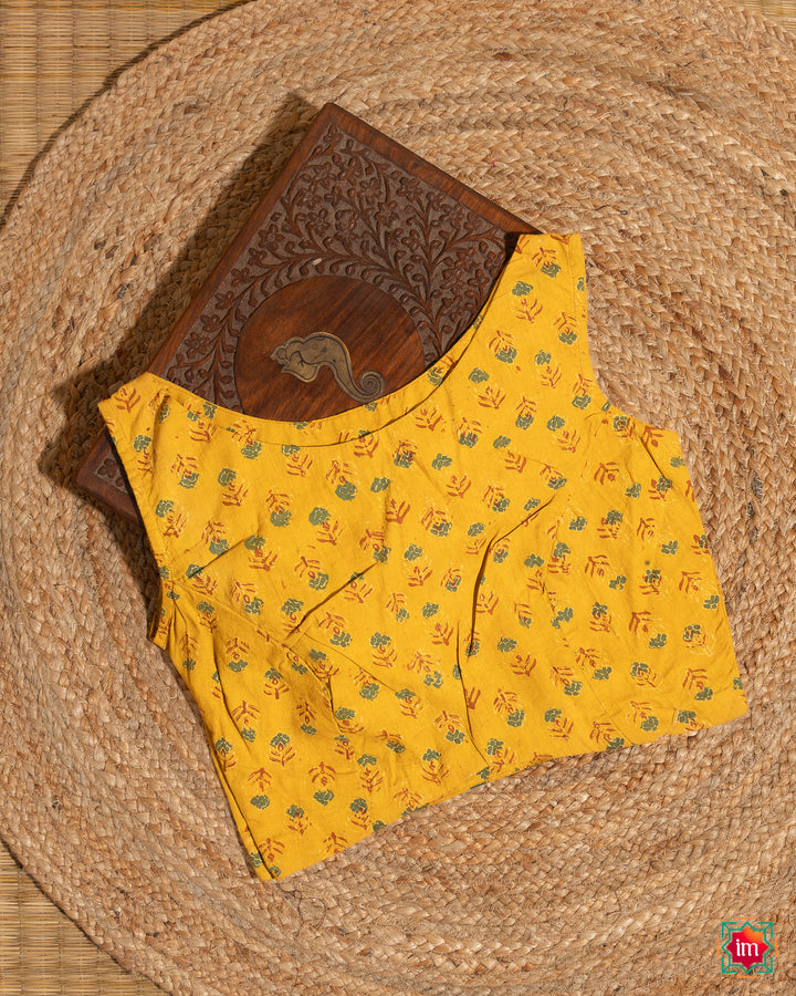 Elegant blouse which would suit any silk saree is kept upon a mat and a wooden designer box.