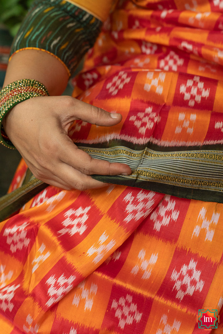 Red yellow silk saree, where in the detailed saree print is displayed.