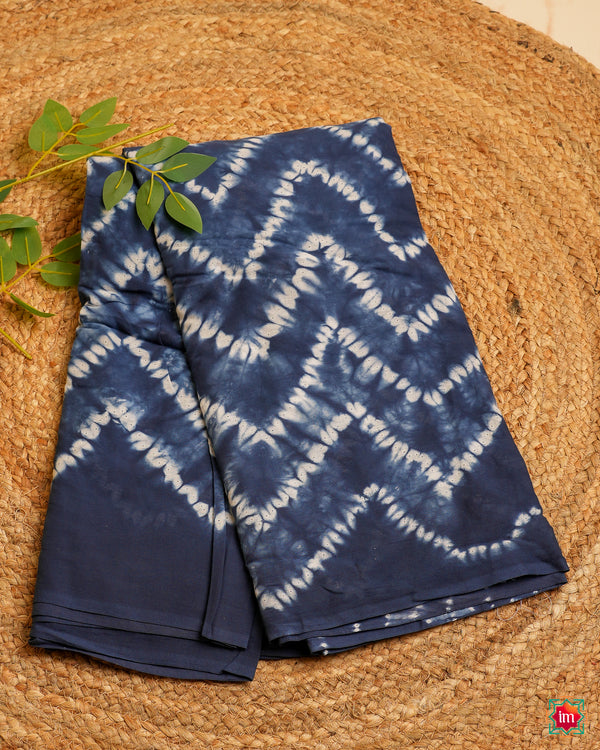 Beautiful blue handloom saree is kept on a jute mat.