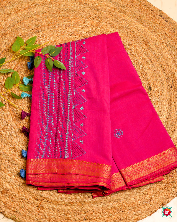 Beautiful pink handloom saree is kept on a jute mat.