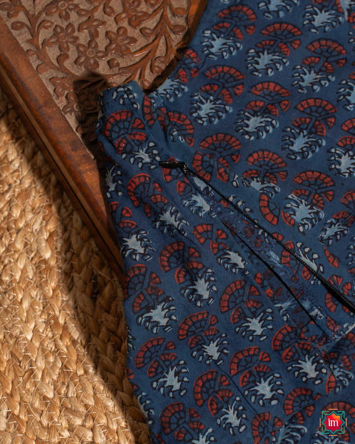 Elegant blouse which would suit any silk saree is kept upon a mat and a wooden designer box.